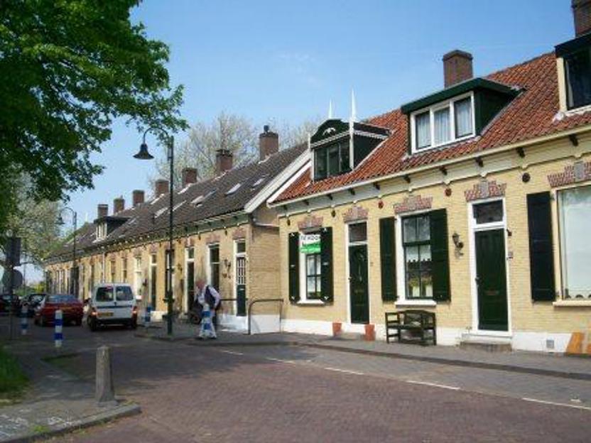 Lange rijen arbeiderswoningen aan de Veerkade in Kinderdijk, naast de ICH scheepswerf