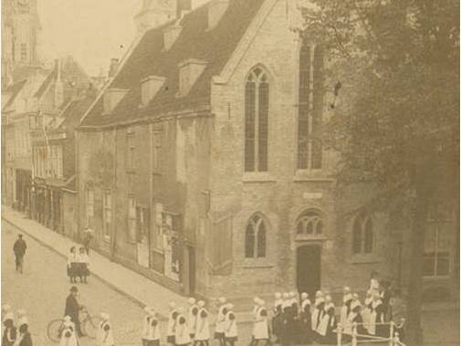 De weesmeisjes wandelen van het Meisjeshuis naar de Oude Kerk.