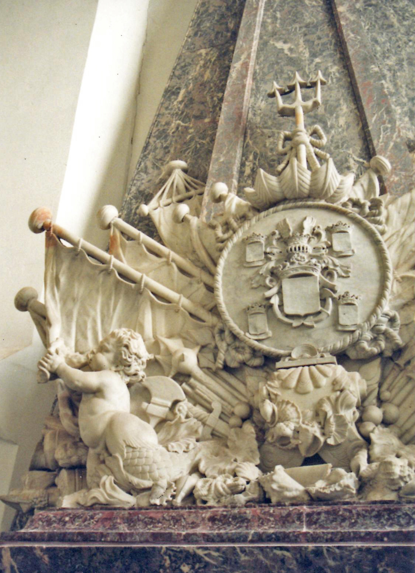 Detail praalgraf voor vlootvoogd Philips van Almonde in de Catharijnekerk te Brielle. Het wapenschild wordt omgeven door maritieme symbolen zoals zeilen, schelpen en de drietand van Neptunus. Ook oorlogstuig, zoals kanonnen en knotsen, ontbreekt niet. Grappig zijn de watergeesten onderaan: mollige jongetjes met een vissenstaart die op een schelp blazen. Foto: M. Hulsman
