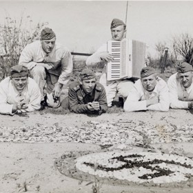 De hoek van de foto is niet geweldig, maar de mannen poseren hier op het voormalige eiland De Beer voor hun met schelpen en zeewier gemaakte adelaar. Op de achtergrond zijn schoorsteentjes en wat nieuwe beplanting zichtbaar.