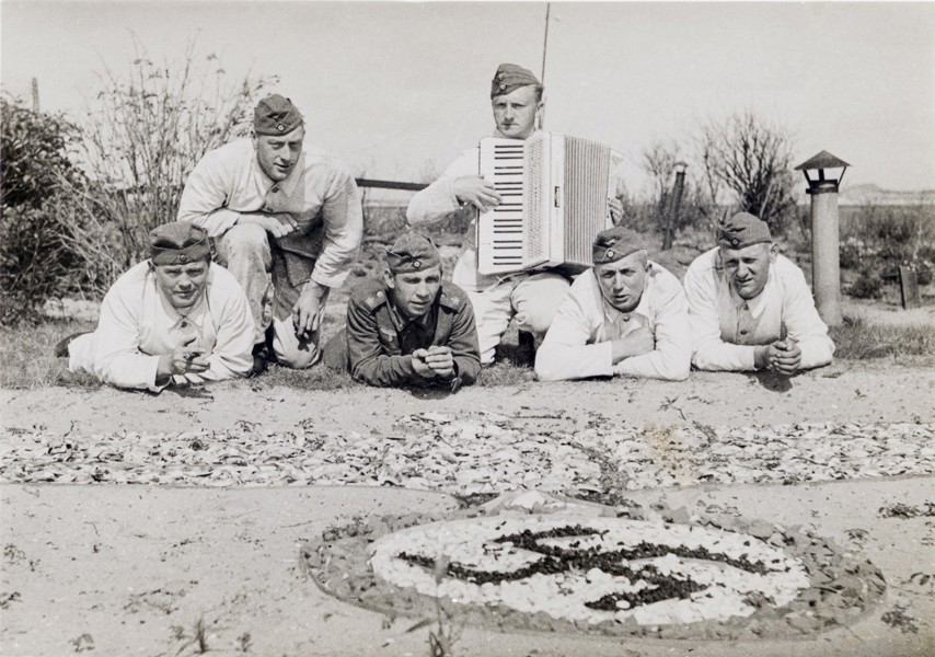 De hoek van de foto is niet geweldig, maar de mannen poseren hier op het voormalige eiland De Beer voor hun met schelpen en zeewier gemaakte adelaar. Op de achtergrond zijn schoorsteentjes en wat nieuwe beplanting zichtbaar.