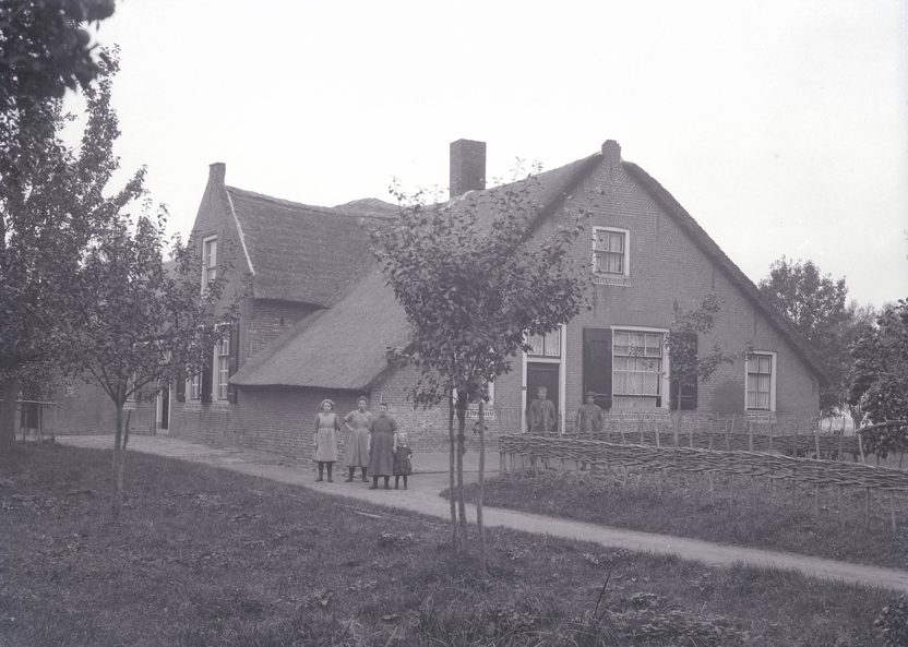 Afbeelding van een familie voor een hallehuisboerderij in Meerkerk, gemeenten Alblasserwaard (Foto: Klaas Uilkema, 1924 / Rijksdienst voor Cultureel Erfgoed)