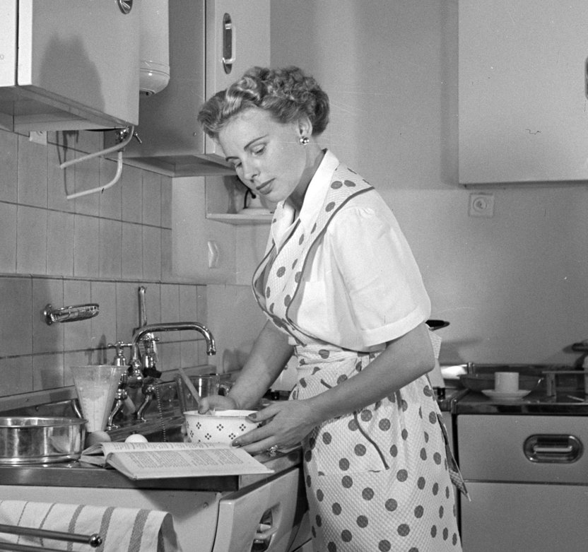 Willem van de Poll, Huisvrouw in modelkeuken bezig met het maken van een taart. Foto in het boek 