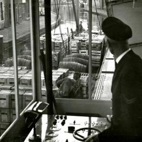 De brugwachter aan het bedieningspaneel in het brugwachtershuisje van de Ooievaarsbrug over de Schie in Schiedam, 1962 (Foto H. Visser, Collectie Gemeentearchief Schiedam)