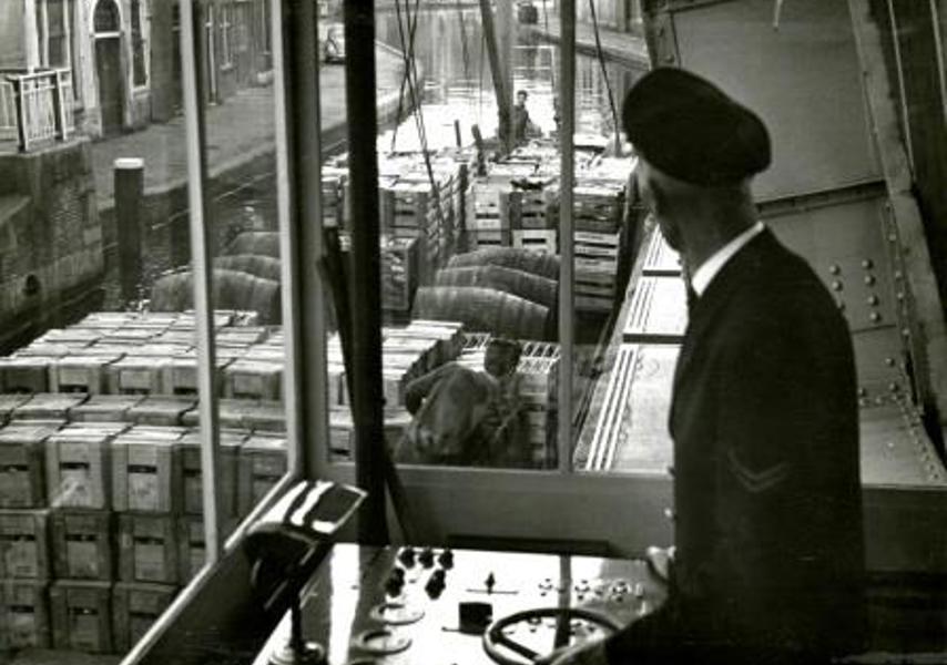 De brugwachter aan het bedieningspaneel in het brugwachtershuisje van de Ooievaarsbrug over de Schie in Schiedam, 1962 (Foto H. Visser, Collectie Gemeentearchief Schiedam)