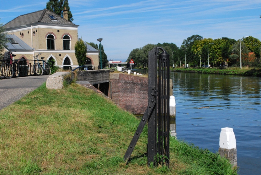 Aan het jaagpad langs de Vliet ten zuiden van Rijswijk ligt het (stoom)gemaal van de Plaspoelpolder uit 1873. In de berm is een rolpaal te zien, die diende om trekschuiten de bocht om te trekken zonder dat de schuit naar de wal dreef. Iets verderop langs het Jaagpad ligt de herberg Vlietzigt. (Foto: Erfgoedhuis Zuid-Holland)