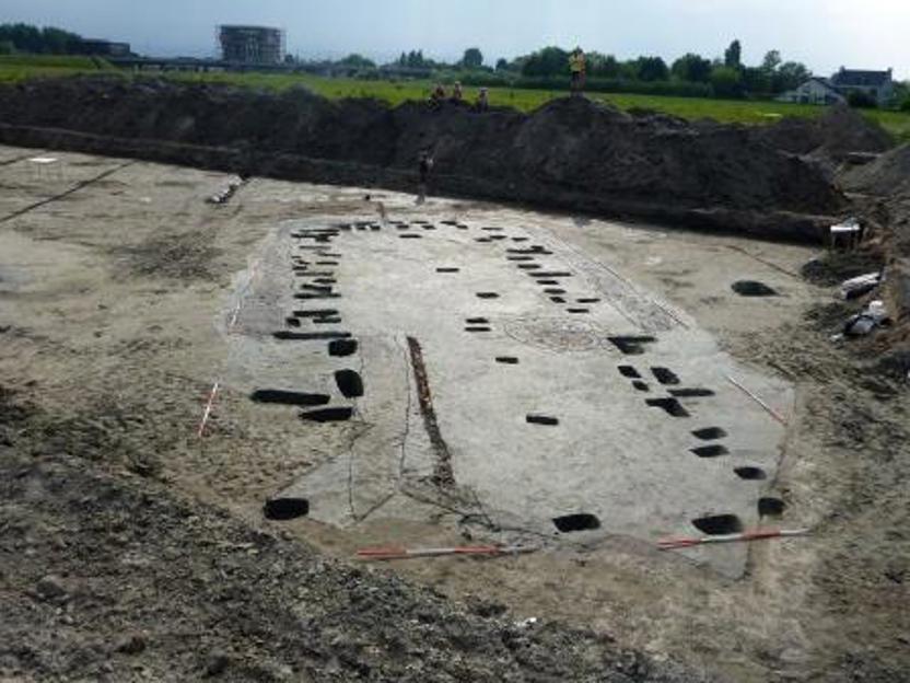 Vanaf de storthopen kijken archeologen naar de uitgegraven paalsporen van een vroegmiddeleeuws huis dat ze bij Oegstgeest hebben opgegraven. Duidelijk zijn de tegenover elkaar liggende ingangspartijen te zien. (Bron: Archol bv) 