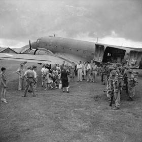 Om de orde in het chaotische Nederlands-Indië te handhaven werden onder meer Brits-Indische troepen ingezet. Soldaten rechts zijn uit een Dajita van Royal Air Force gestrapt op het vliegveld van Bandoeng. Pas bevrijde Nederlandse mannen. vrouwen en kinderen staan klaar om met hetzelfde toestel te worden geëvacueerd.  (Foto Sgt. Woollactott/Imperial War Museum?Collectie Air Ministry Second World War)