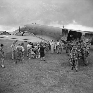 Om de orde in het chaotische Nederlands-Indië te handhaven werden onder meer Brits-Indische troepen ingezet. Soldaten rechts zijn uit een Dajita van Royal Air Force gestrapt op het vliegveld van Bandoeng. Pas bevrijde Nederlandse mannen. vrouwen en kinderen staan klaar om met hetzelfde toestel te worden geëvacueerd.  (Foto Sgt. Woollactott/Imperial War Museum?Collectie Air Ministry Second World War)