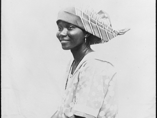 De kunstig gevouwen en gesteven angisa maakt de dracht van de kotomisi compleet. Surinaamse vrouw, ca. 1910-1941. (foto Collectie Wereldmuseum)